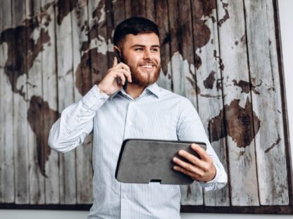 Handsome busy businessman talking on the phone and looking at important document on tablet. Handsome busy businessman talking on the phone and looking at important document on tablet.